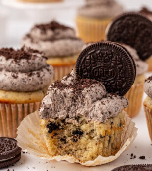 a cookies and cream cupcake, topped with Oreo buttercream and a whole cookie, with a bite missing