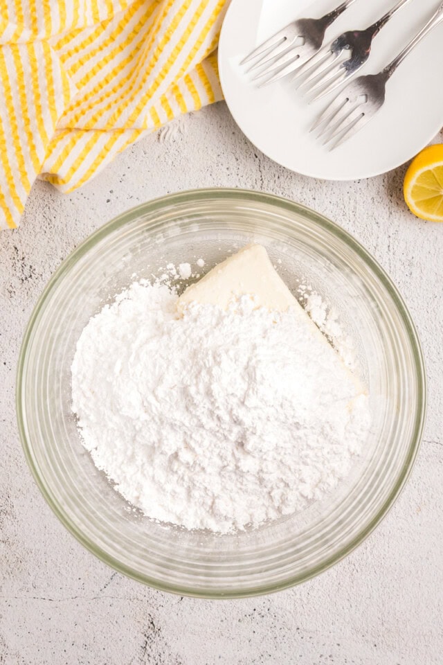 overhead view of cream cheese and confectioners' sugar in a mixing bowl
