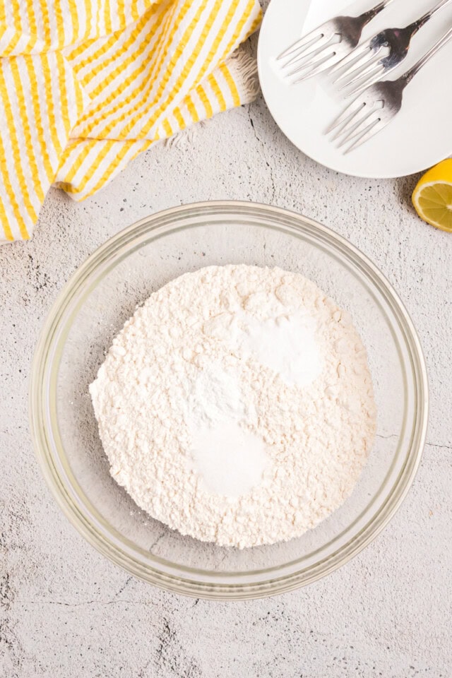 overhead view of flour, baking powder, baking soda, and salt in a mixing bowl