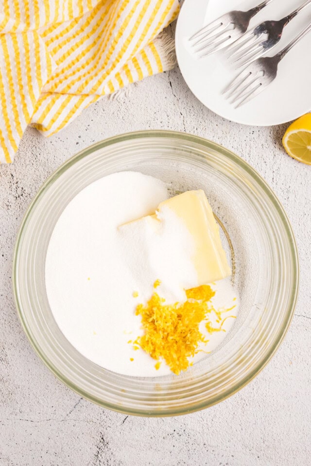 overhead view of butter, sugar, and lemon zest in a mixing bowl