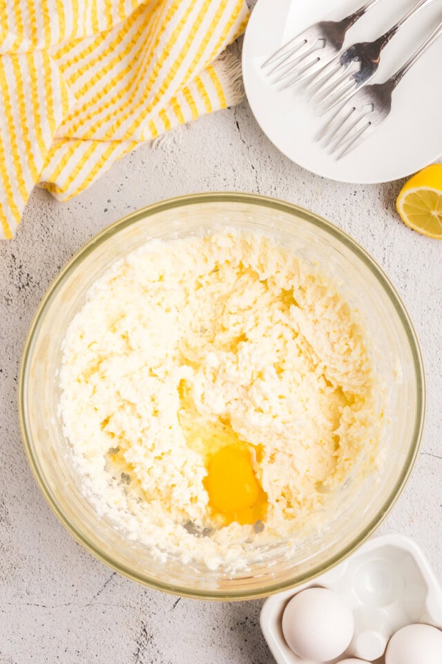 overhead view of egg added to creamed butter and sugar