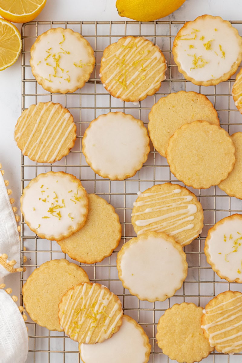 overhead view of lemon shortbread cookies topped with lemon glaze and zest on a wire rack