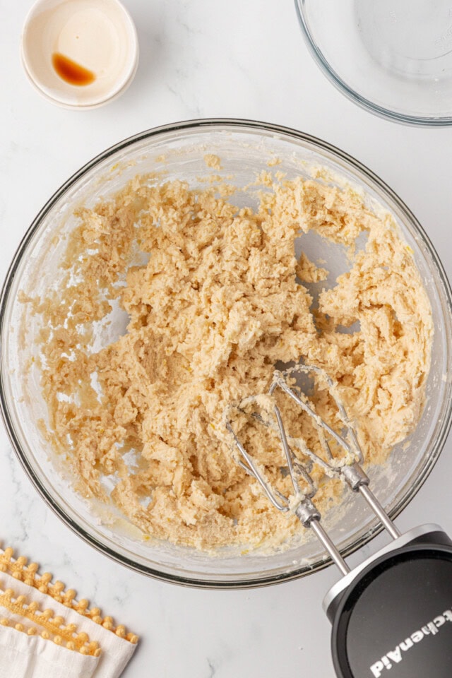 overhead view of lemon shortbread cookie dough in a glass mixing bowl