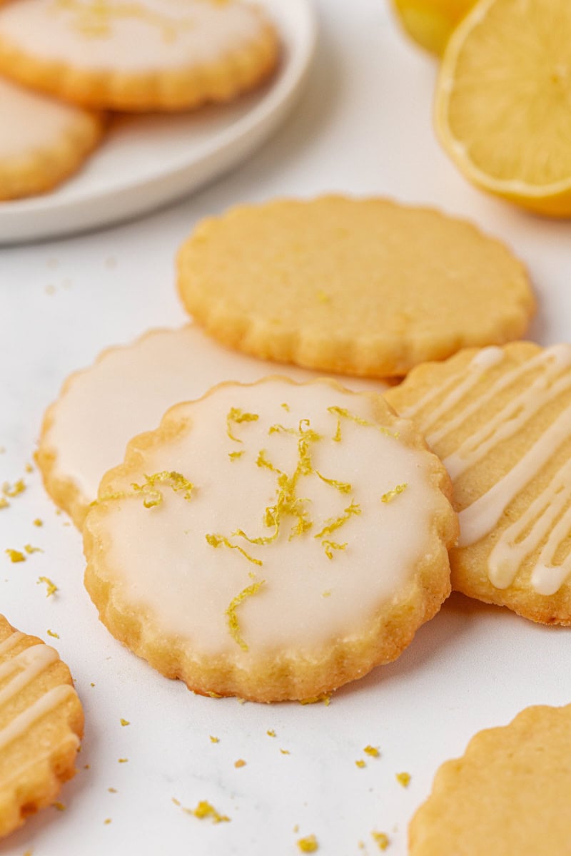 lemon shortbread cookies topped with a smooth lemon glaze and fresh lemon zest
