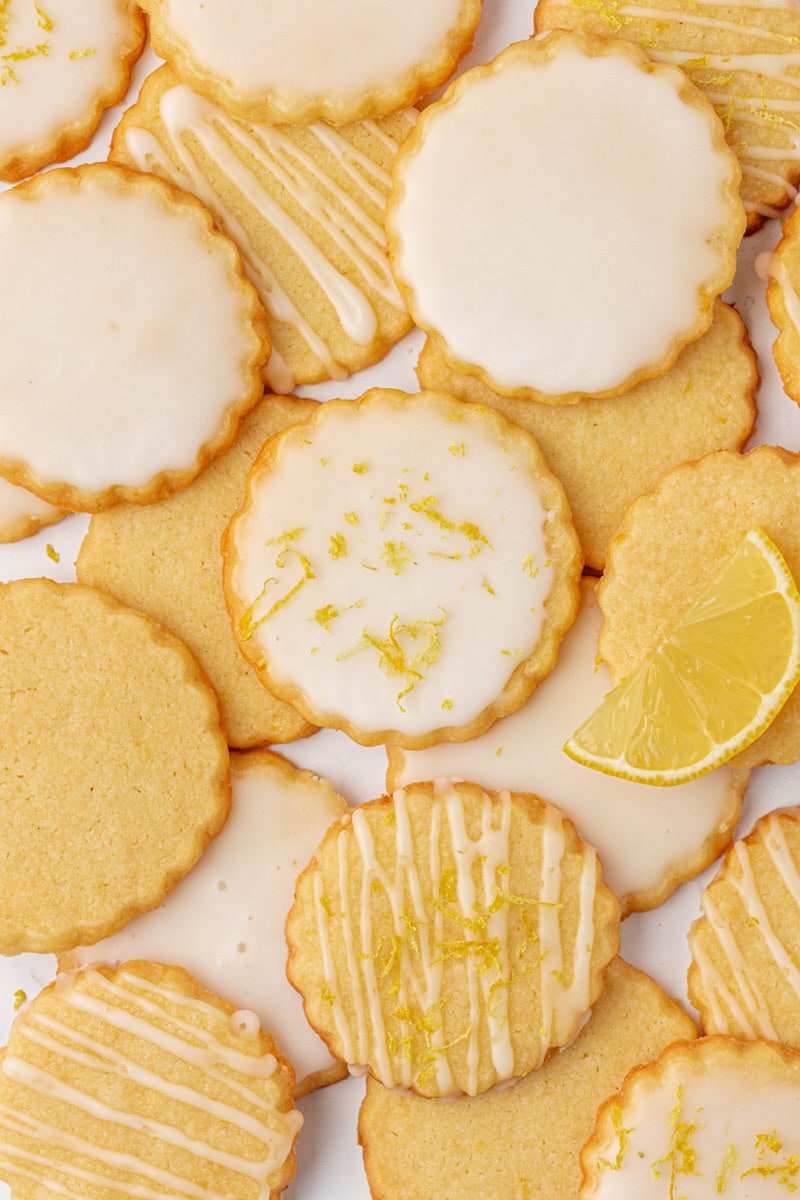 overhead view of several lemon shortbread cookies topped with lemon glaze and zest