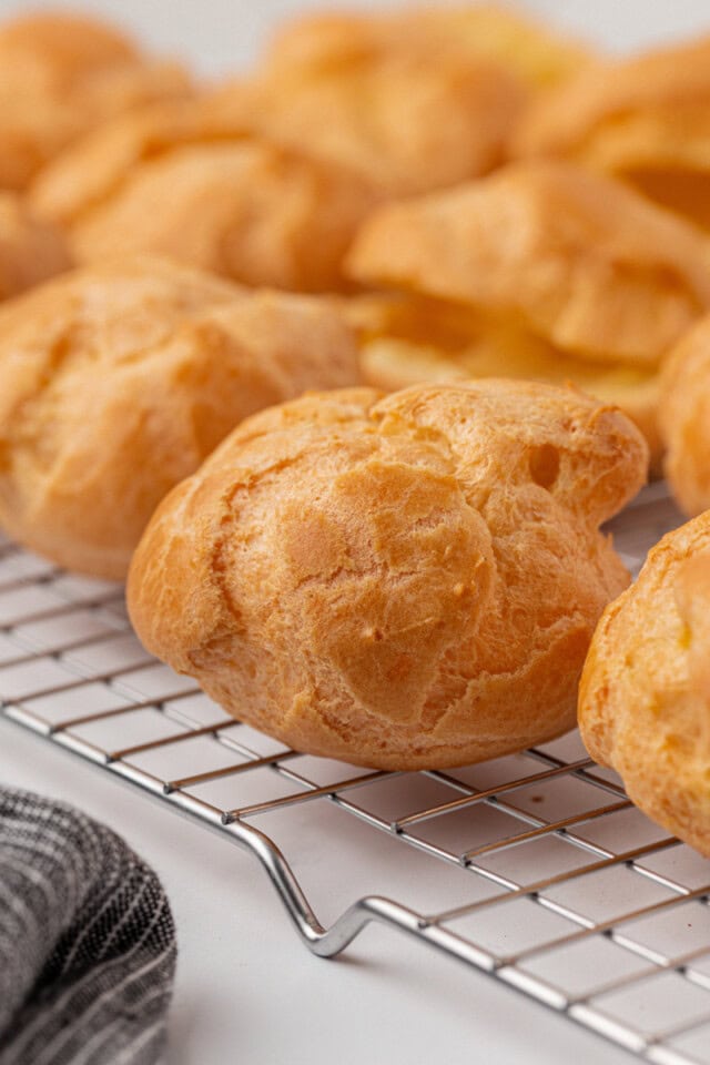 closeup of freshly baked profiteroles cooling on a wire rack