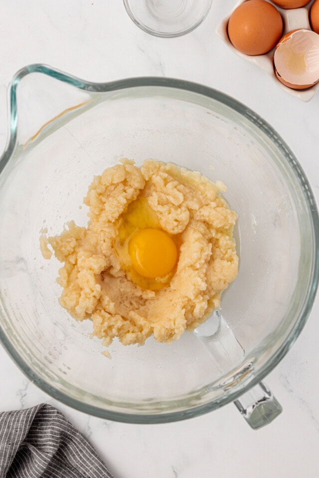 overhead view of egg added to pâte à choux dough