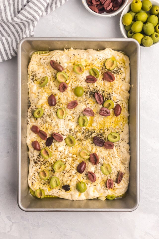overhead view of no-knead focaccia with toppings added, ready to go into the oven