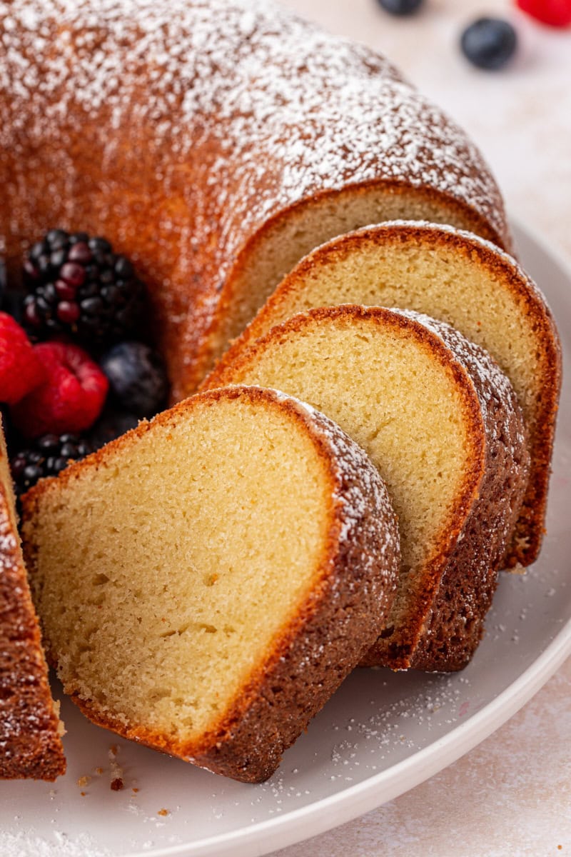 close up of partially sliced buttermilk pound cake topped with powdered sugar