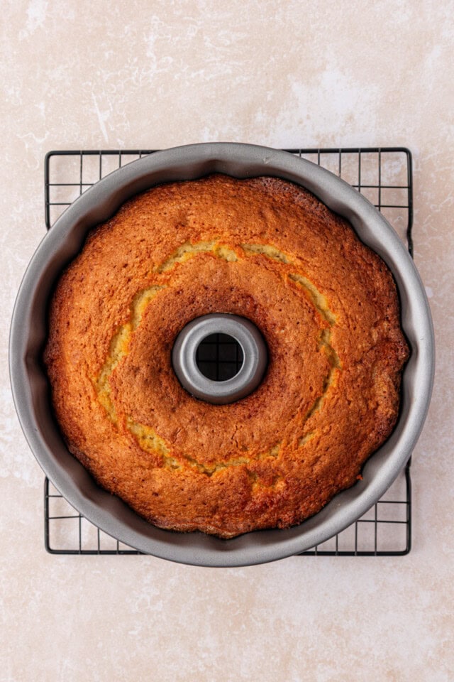 overhead view of freshly baked buttermilk pound cake in a Bundt pan set on a wire cooling rack