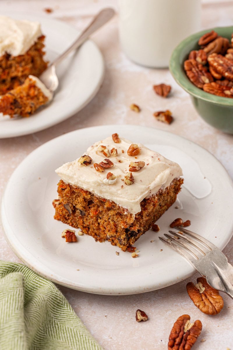 a slice of carrot sheet cake with browned butter cream cheese frosting and chopped nuts