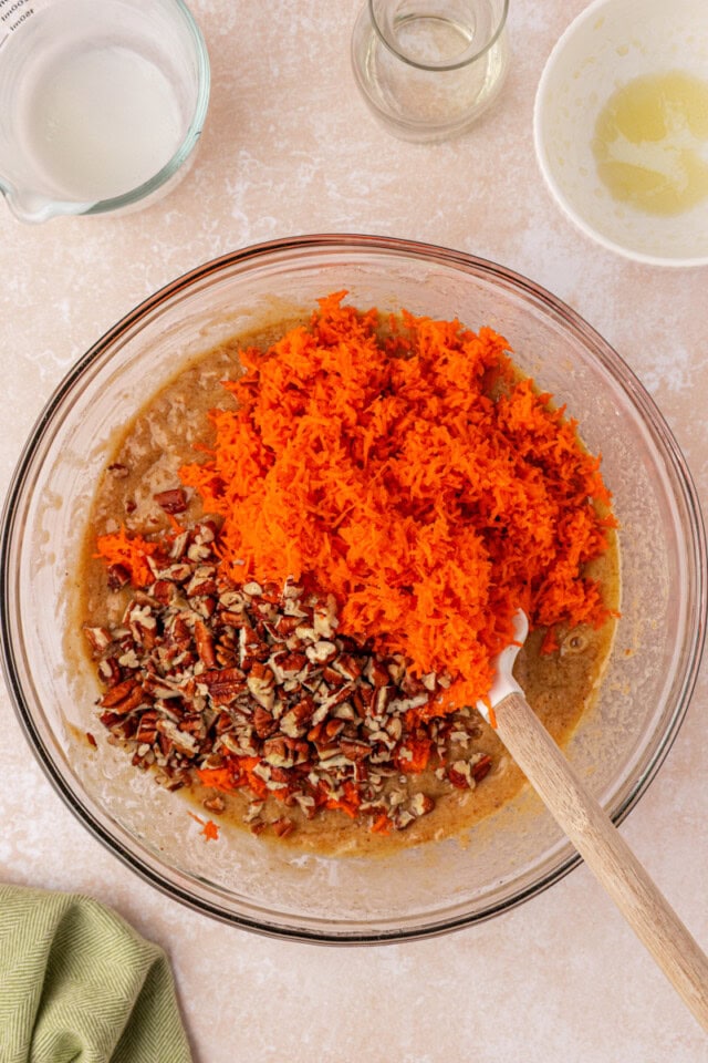 overhead view of grated carrots and chopped nuts added to cake batter