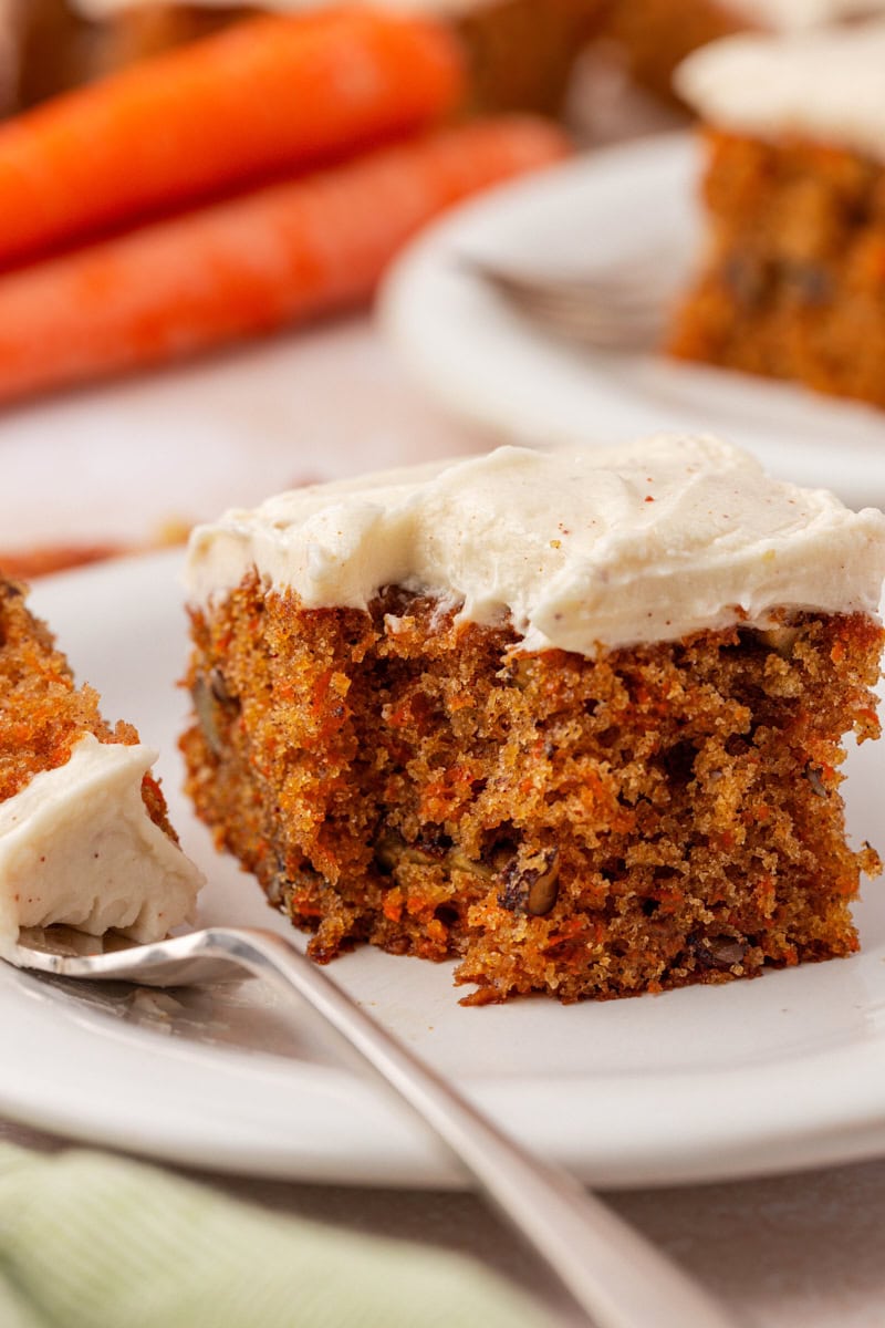 a slice of carrot sheet cake topped with browned butter cream cheese frosting