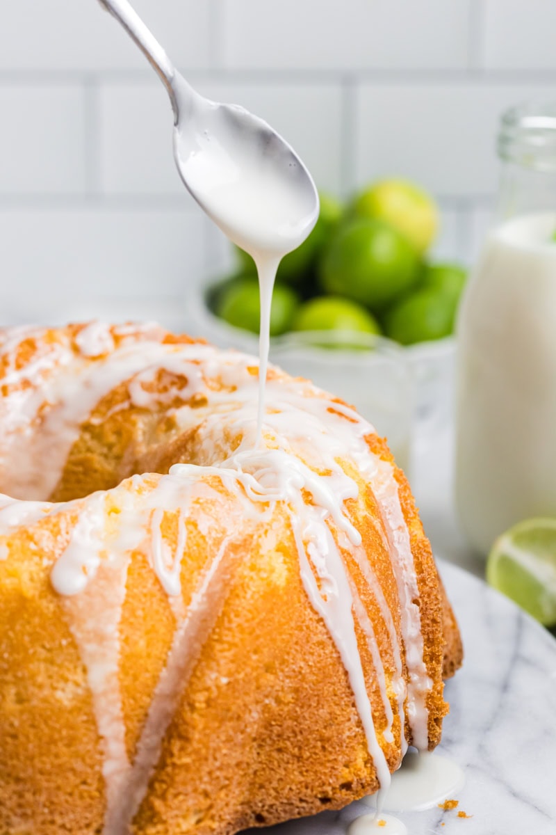 a simple sweet-tart glaze being drizzled over Key lime Bundt cake