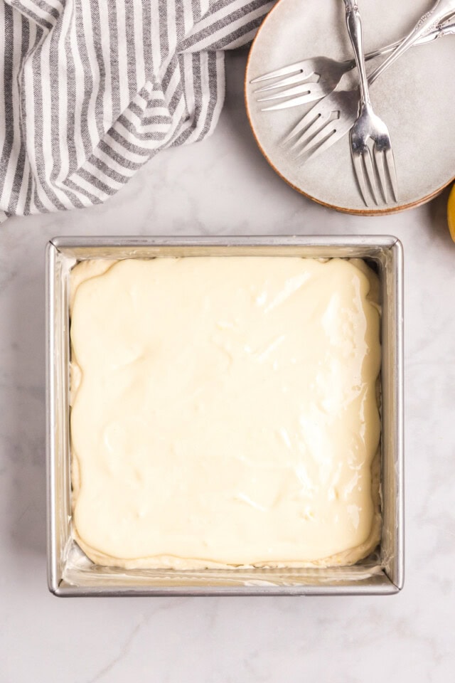 overhead view of cream cheese filling spread over lemon cake