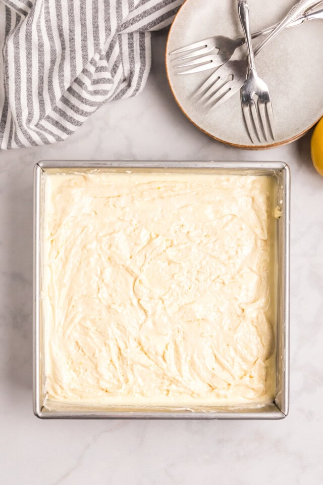 overhead view of cake batter spread over cream cheese filling for lemon cream cheese coffee cake