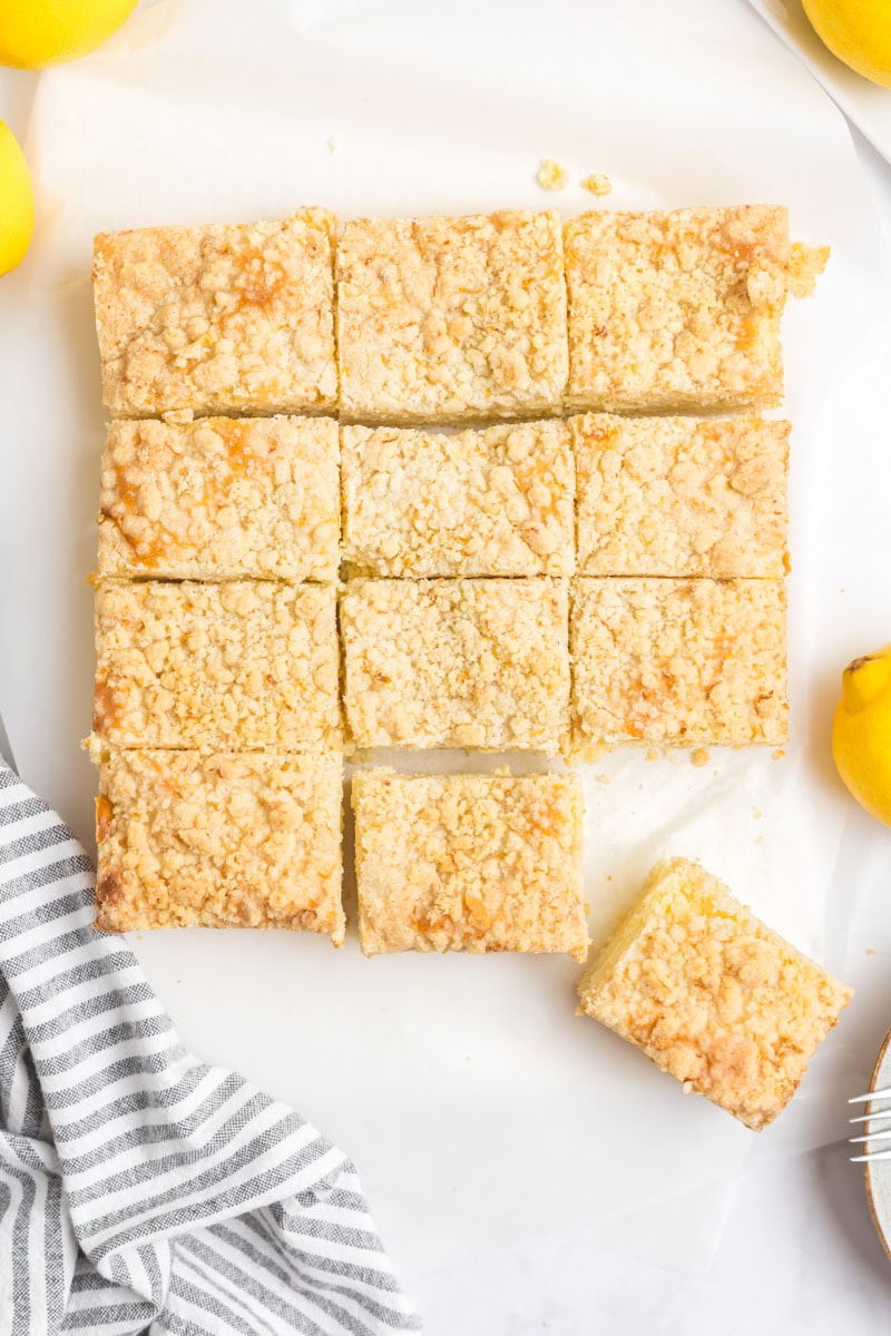 overhead view of sliced lemon cream cheese coffee cake on a white surface