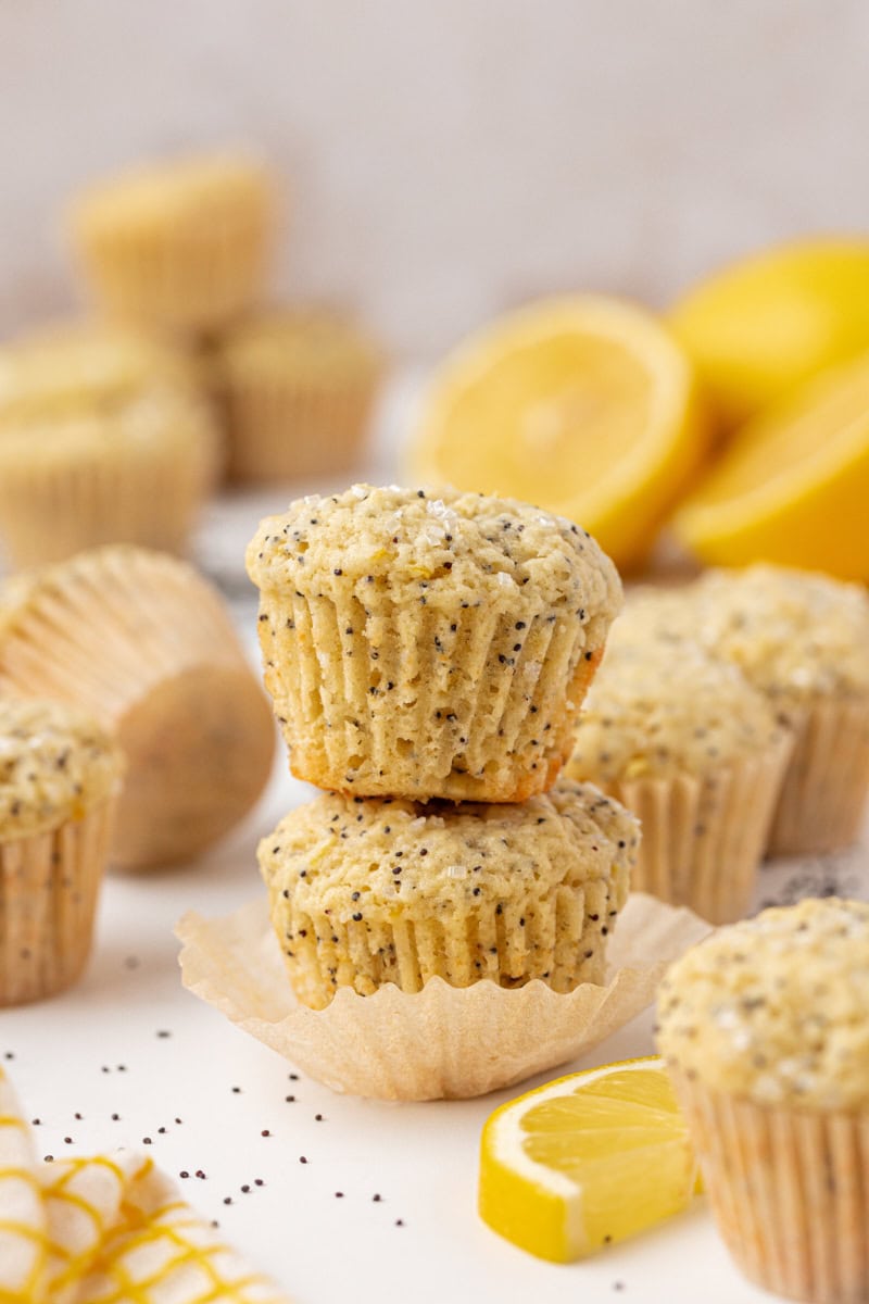 stack of two muffins surrounded by more muffins and fresh lemon slices