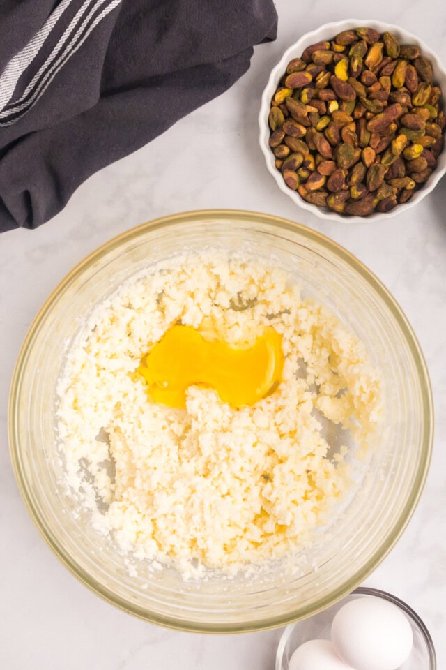 overhead view of egg added to creamed butter and sugar