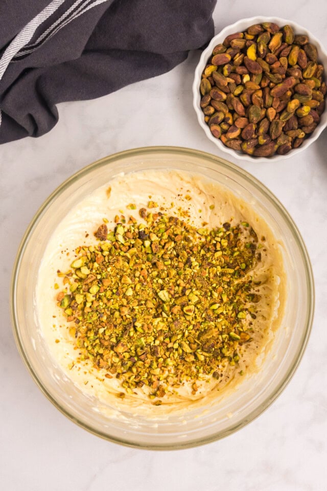 overhead view of chopped pistachios added to cake batter
