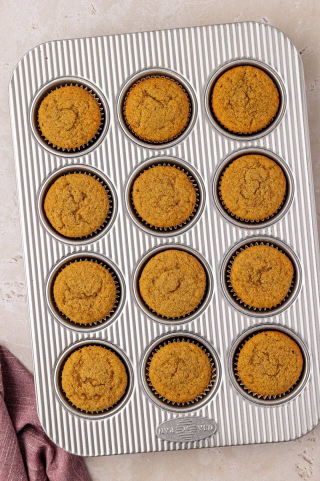 overhead view of freshly baked pistachio cupcakes in a muffin pan