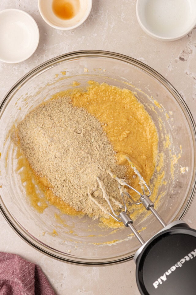 overhead view of dry ingredients added to wet ingredients for pistachio cupcakes