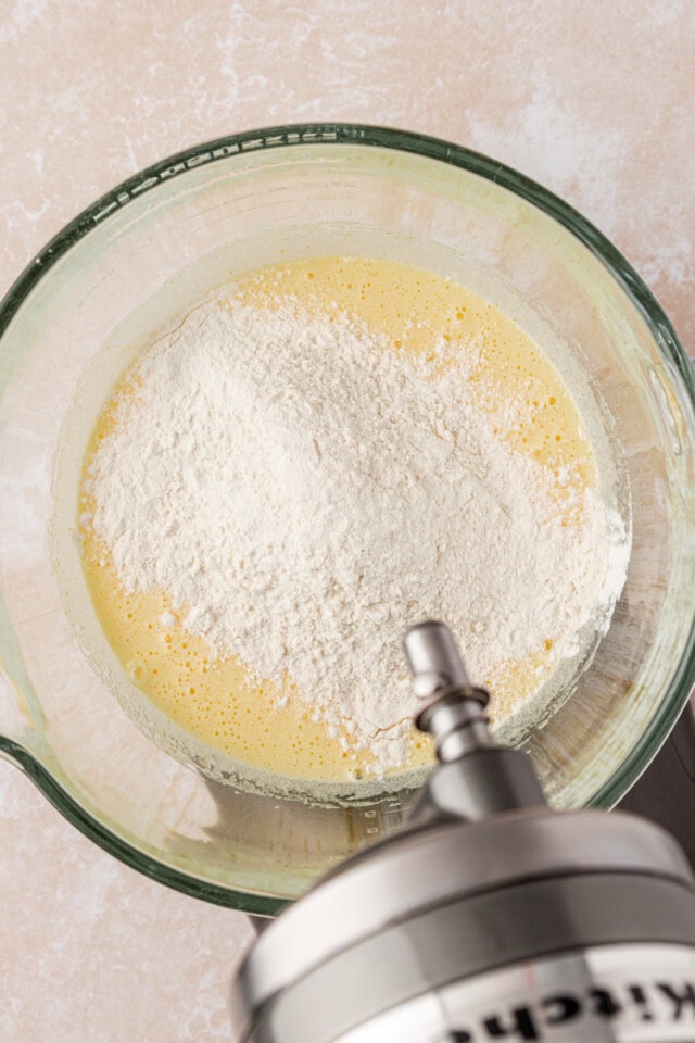overhead view of dry ingredients added to beaten eggs and sugar