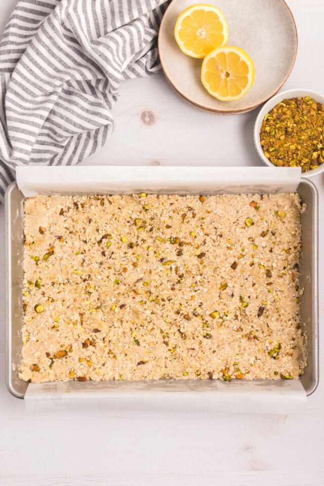 overhead view of pistachio shortbread dough pressed into the bottom of a 9x13 pan