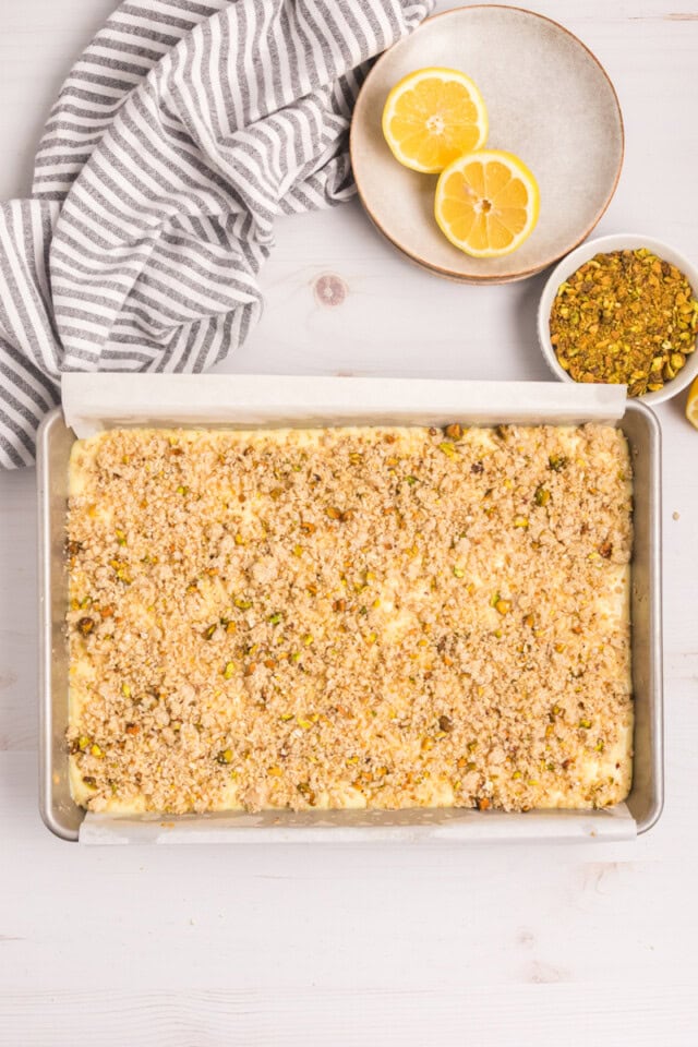 overhead view of lemon pistachio cheesecake bars topped with crumb topping before baking