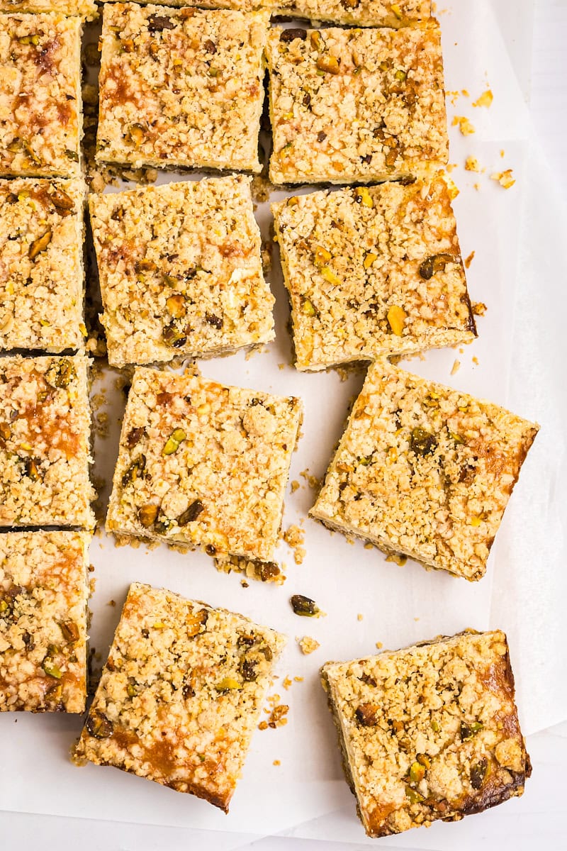 overhead view of sliced lemon cheesecake bars with pistachio crust and crumb topping