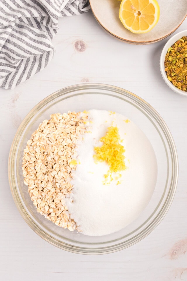 overhead view of flour, oats, sugar, and lemon zest in a mixing bowl