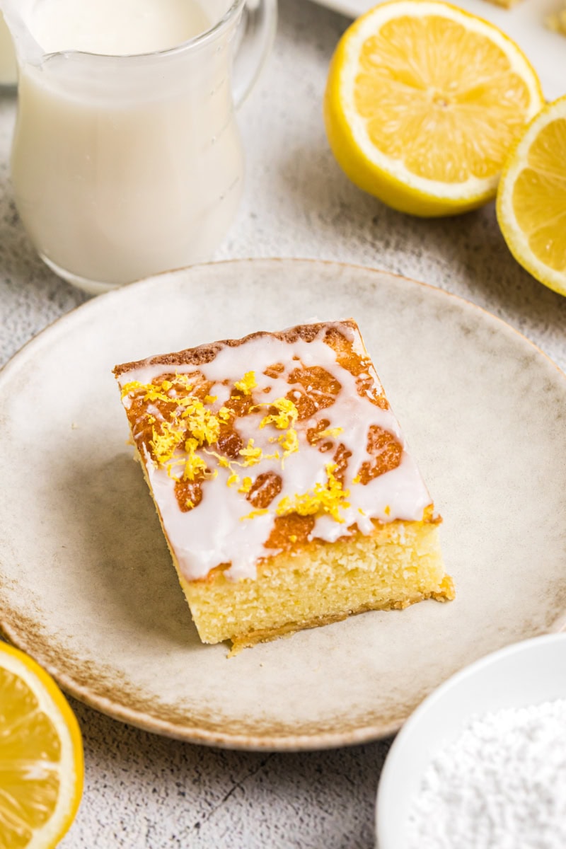 a lemon pound cake bar topped with a lemony glaze and lemon zest