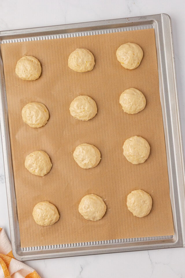 lemon whoopie pies portioned onto a lined baking sheet ready to go into the oven