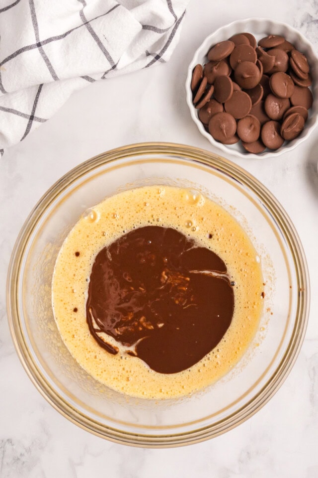 overhead view of melted chocolate mixture added to wet ingredients for brownies