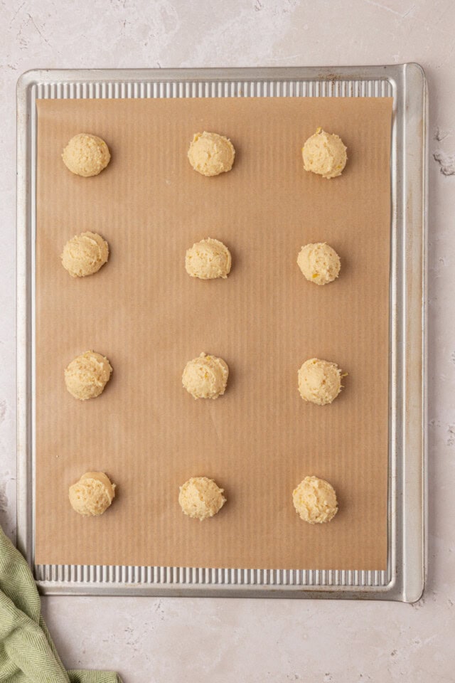 overhead view of ricotta cookies scooped onto a parchment-lined baking sheet