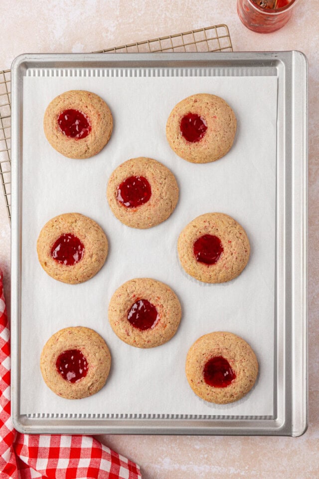 overhead view of freshly baked strawberry shortcake cookies on a lined baking sheet