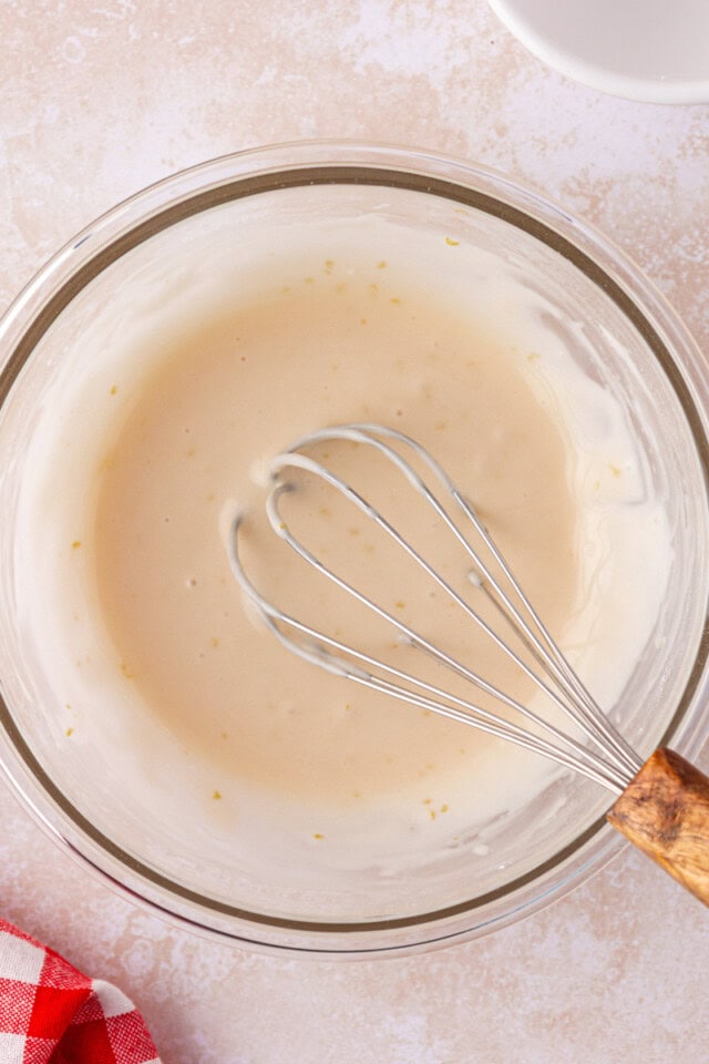 overhead view of sweet cream glaze in a mixing bowl with a whisk