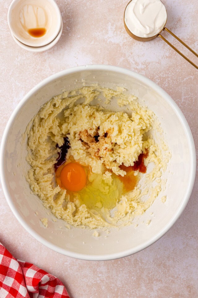 overhead view of egg, vanilla, and almond extract added to creamed butter and sugar
