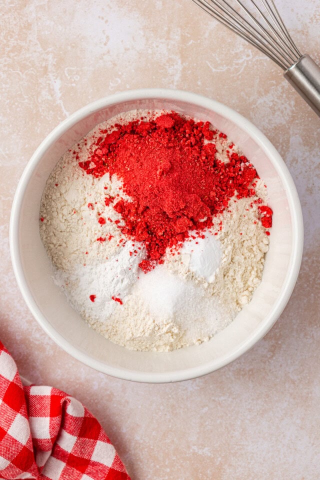 overhead view of flour, freeze-dried strawberry powder, baking powder, baking soda, and salt in a mixing bowl