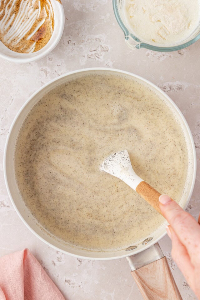 overhead view of heavy cream, milk, sugar, and vanilla bean paste cooked to steaming in a saucepan