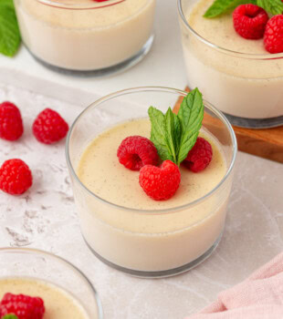Portions de panna cotta à la vanille garnies de baies fraîches et de feuilles de menthe