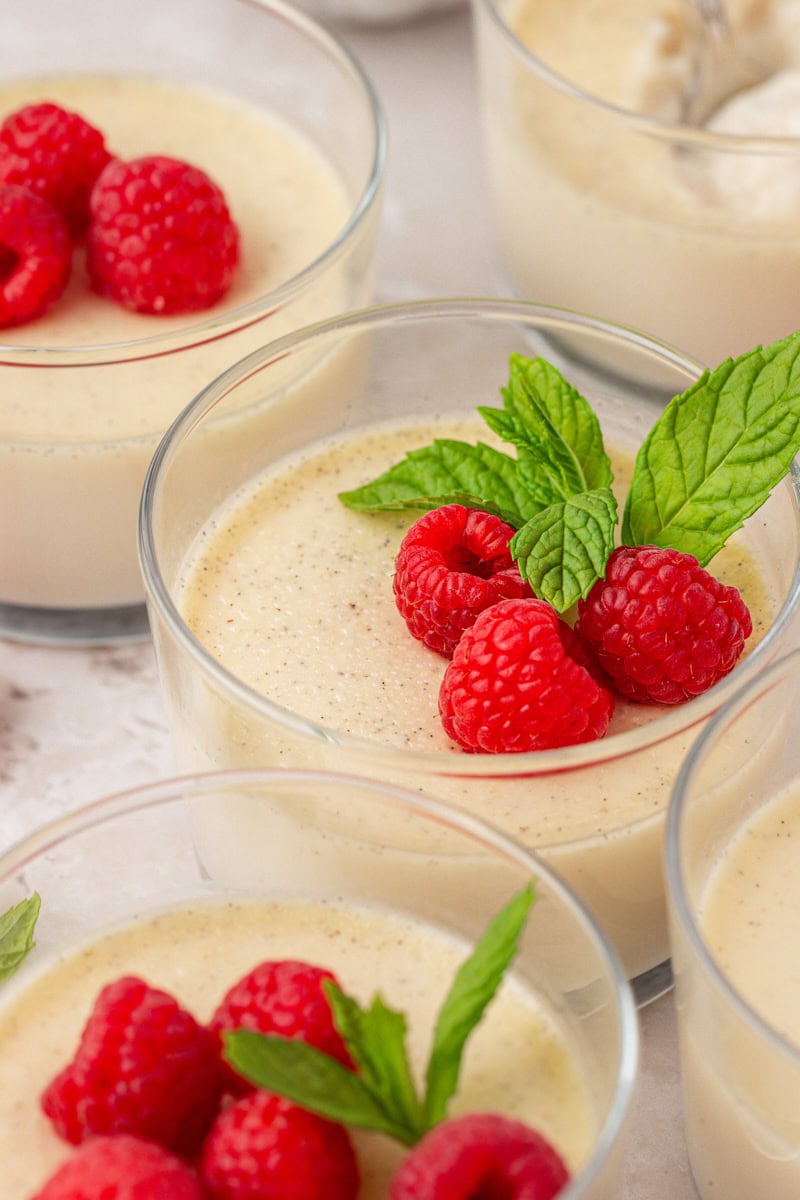 Gros plan de panna cotta à la vanille garnie de baies fraîches et de feuilles de menthe