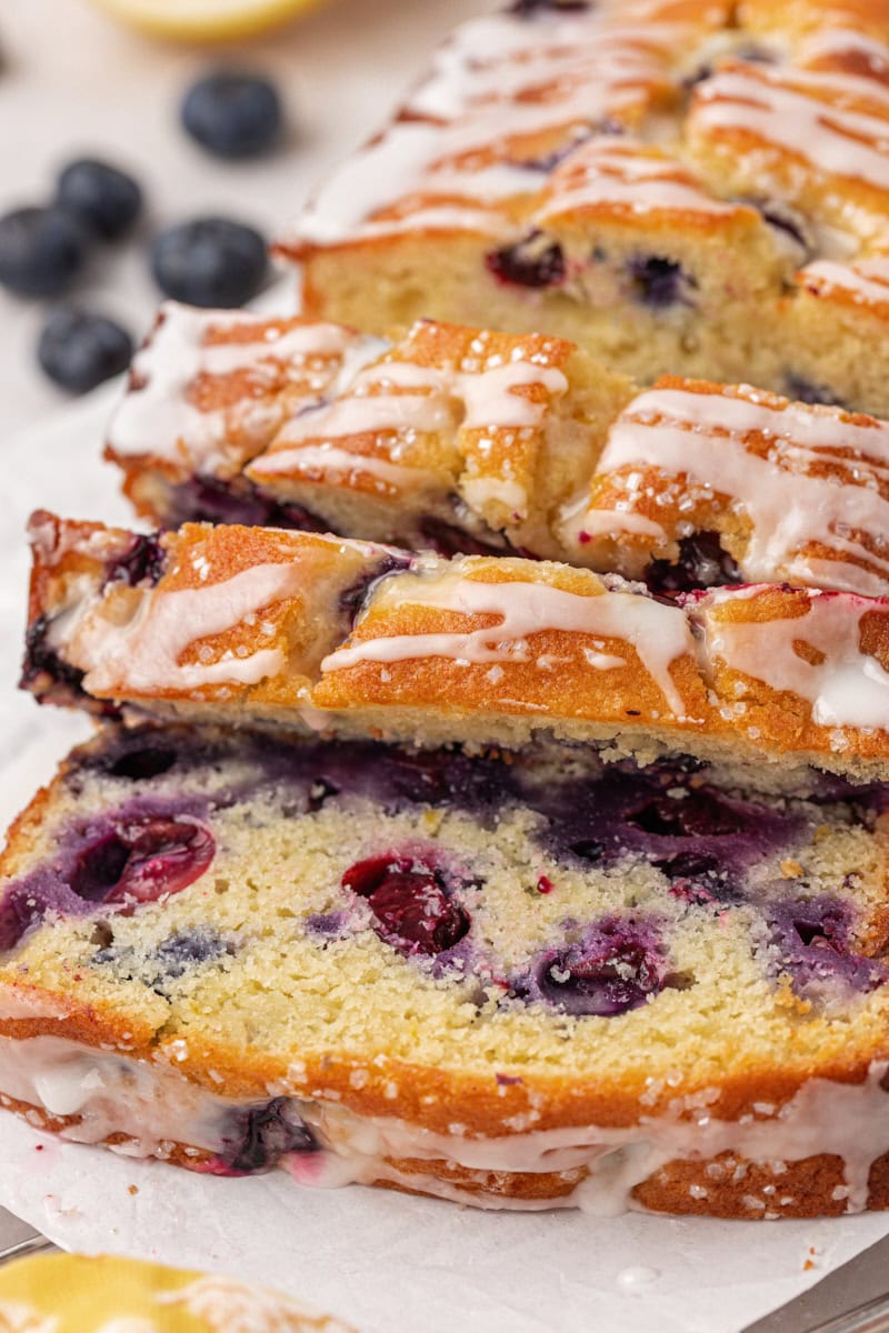 partially sliced blueberry ricotta cake topped with lemon glaze