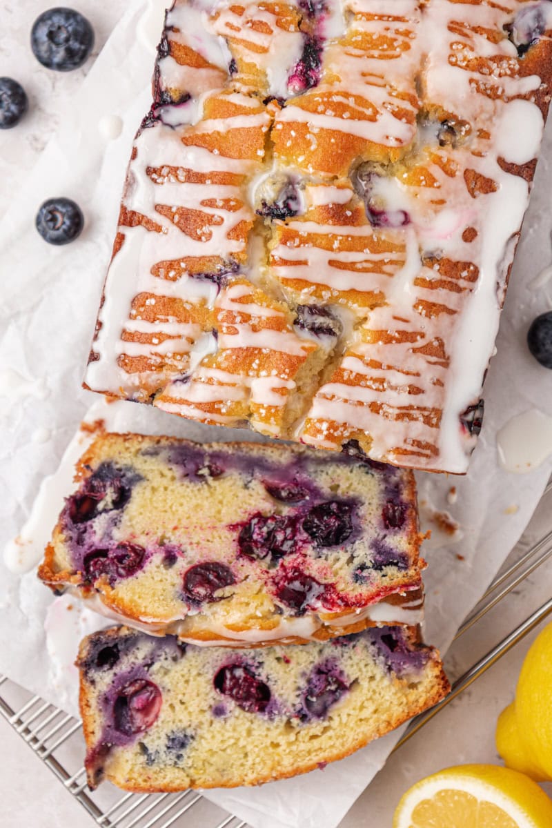overhead view of partially sliced blueberry loaf cake with a lemon glaze