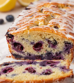 partially sliced blueberry ricotta loaf cake showing the soft texture and berries throughout the cake