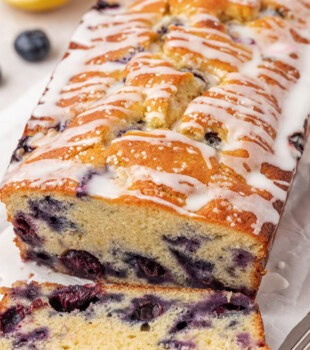 partially sliced blueberry ricotta loaf cake with lemon glaze