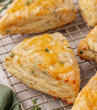 close-up of an herb and cheese scone on a wire rack