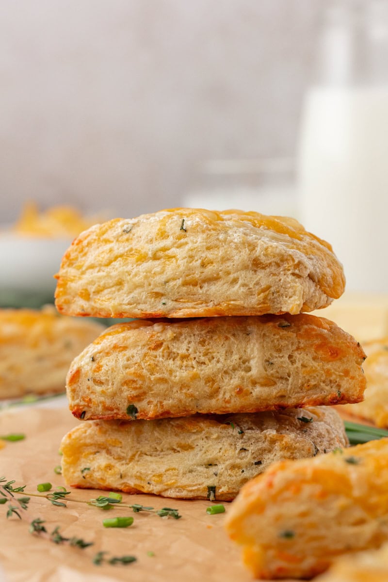 side view of a stack of three herb and cheese scones showing the buttery, flaky layers
