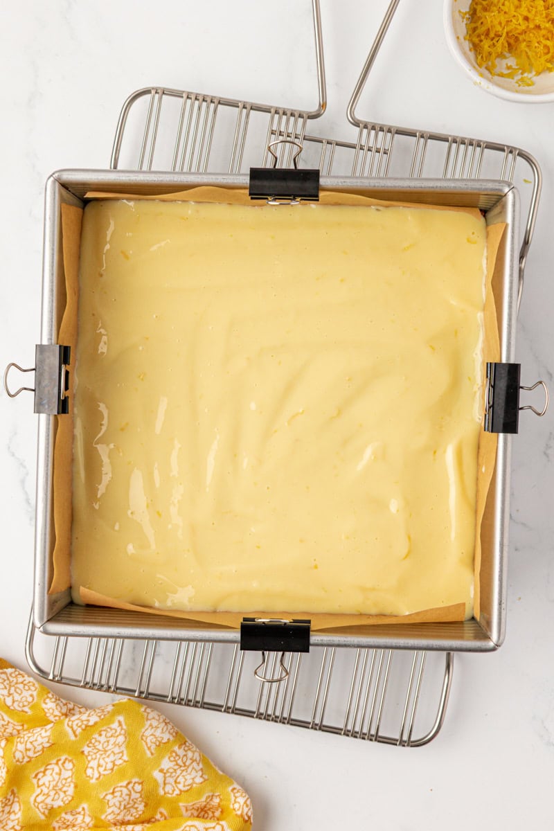 overhead view of lemon icebox bars in a square baking pan before going into the oven