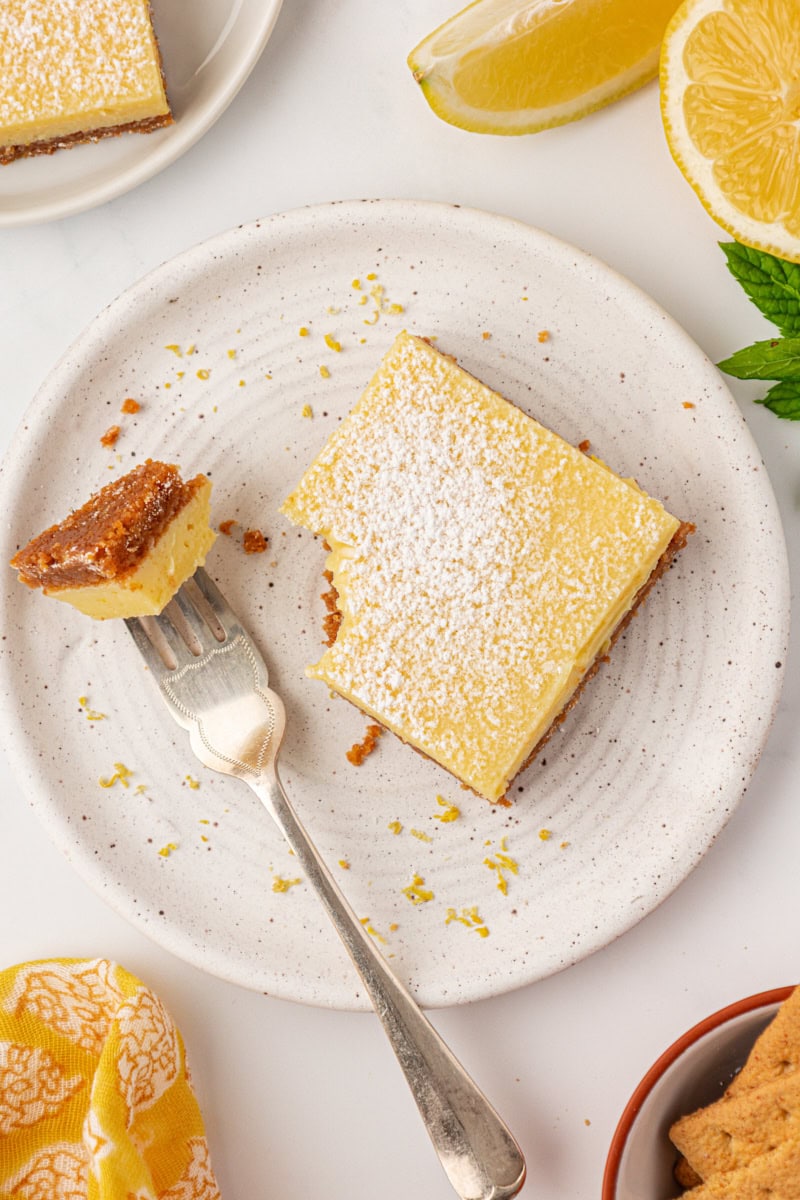 a lemon icebox bar on a plate with a bite on a fork